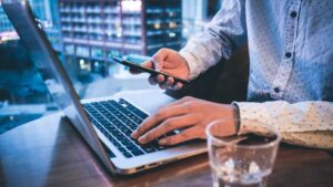 Man using a laptop and a phone