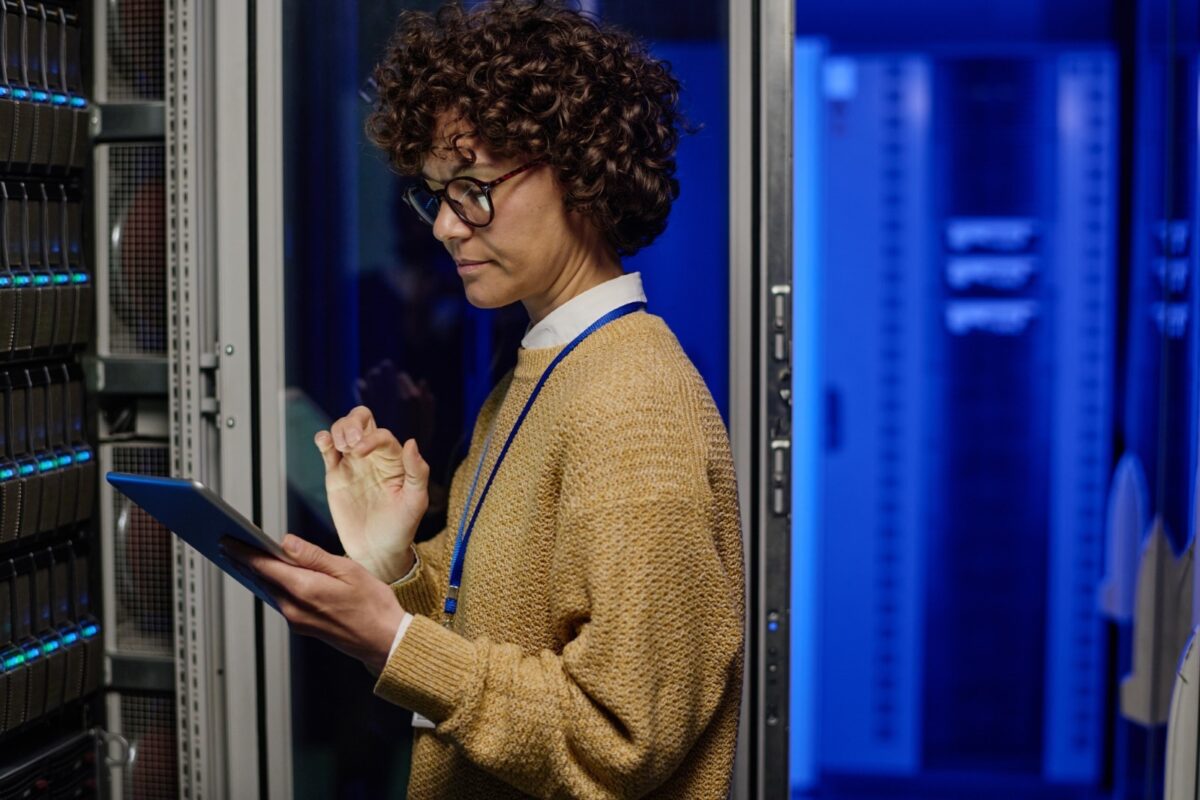 a mixed race woman using a tablet in a data centre