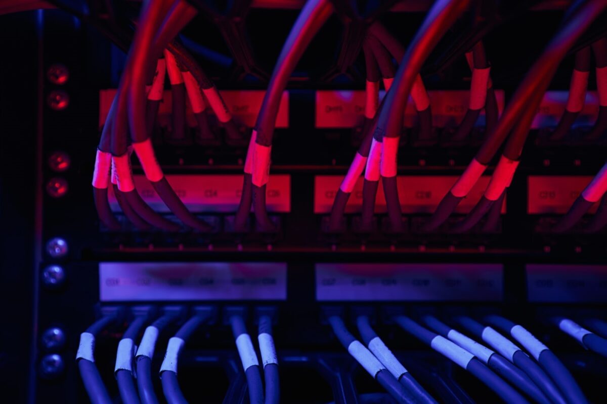 a cable patch bay with blue and pink lighting